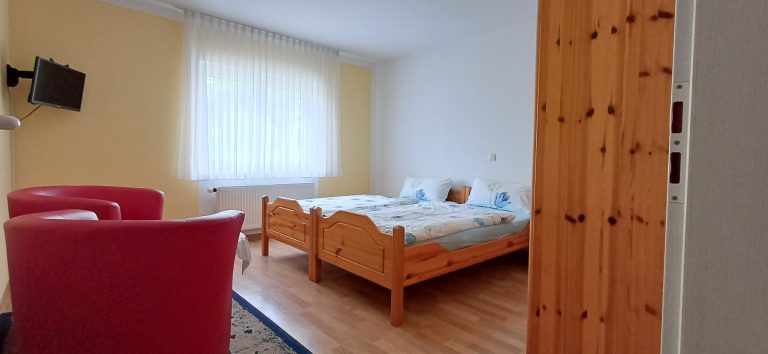 Schlafzimmer 2 – Gästehaus am Weinberg Sinsheim Schlafzimmer mit zwei Einzelbetten aus Holz.